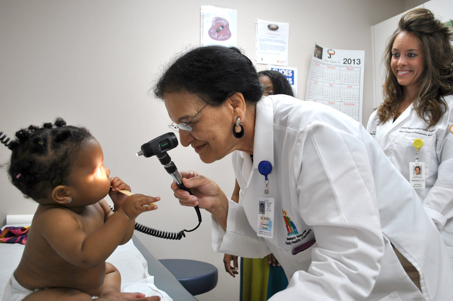 Pediatric residents with a young patient - Detroit GME Authority Health